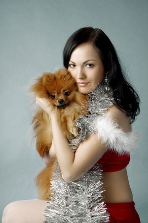 Images of a beautiful santa girl holding dog in the hands ofの写真素材