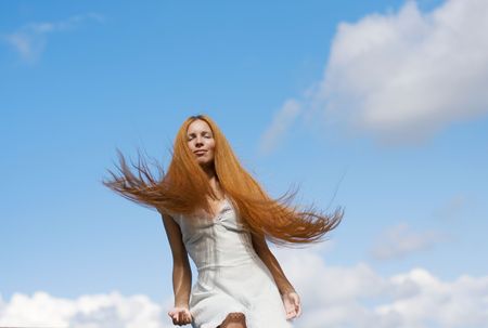 Image of beautiful girl with red hair flying in the skyの写真素材