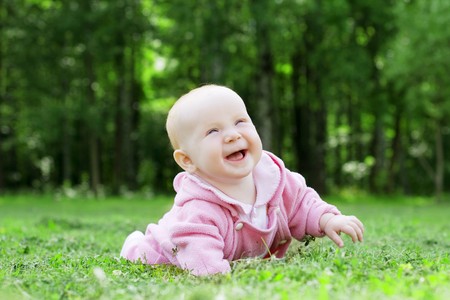 Image of a child lying on the grass in the parkの写真素材