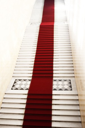 Image on the staircase with red carpet, illuminated by lightの写真素材