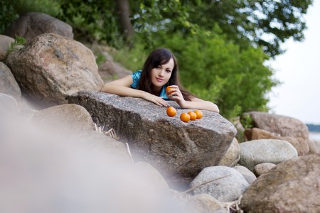 The image of a beautiful young girl with the mandarins in natureの写真素材