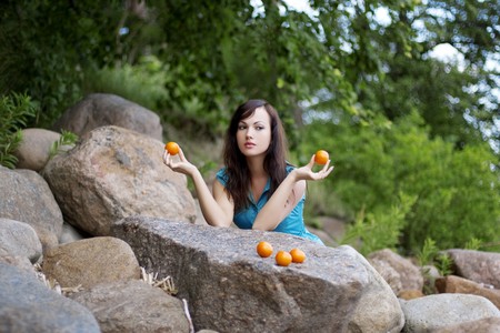 The image of a beautiful young girl with the mandarins in natureの写真素材