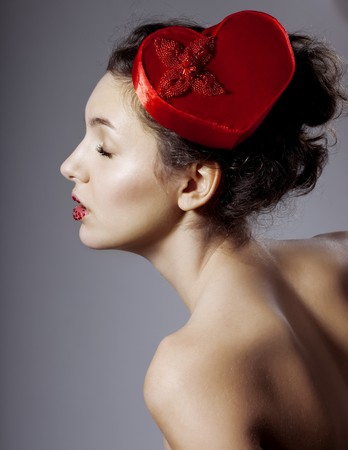 The image of a glamorous beautiful girl in an elegant hat in the form of heart