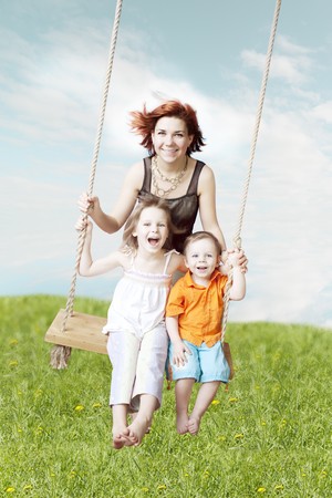 Images of the family swing against the sky and grassの写真素材