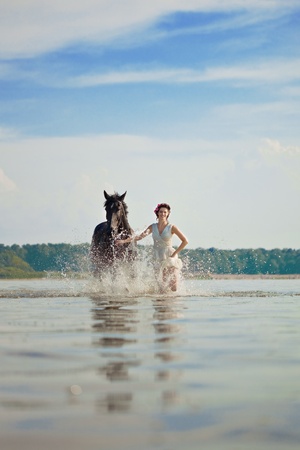 Image of a woman on a horse by the seaの写真素材