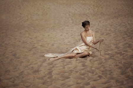 Picture of woman in flying gold cloth in the sand
の写真素材