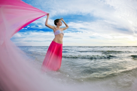 Woman with a tissue in his hands on the beach near the waterの写真素材