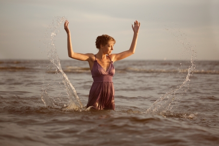 Beautiful woman on the beach at sunset.の写真素材
