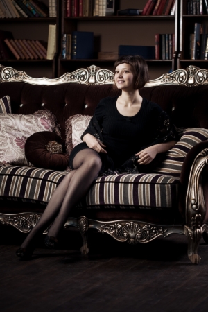 Beautiful woman is sitting on the couchの写真素材