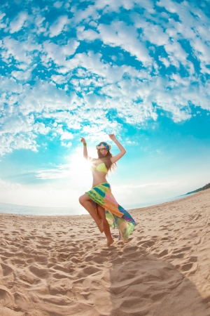 Luxurious beautiful fashionable woman on the beach at sunの写真素材