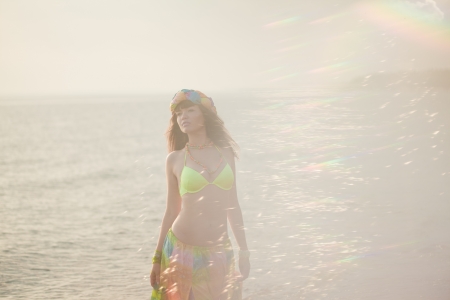 Luxurious beautiful fashionable woman on the beach at sunの写真素材