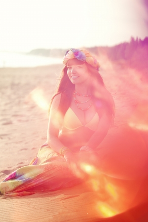Luxurious beautiful fashionable woman on the beach at sunsetの写真素材