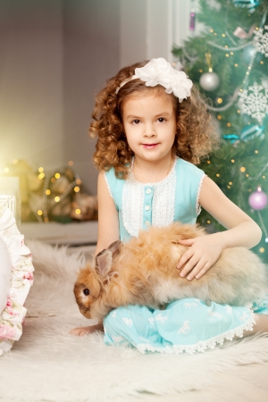 Little smiling Ñhristmas girl with bunnyの写真素材