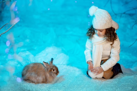 Little cute winter girl with rabbitの写真素材
