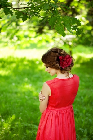 Beautiful woman with a flower in the hairstyle outdoorsの写真素材