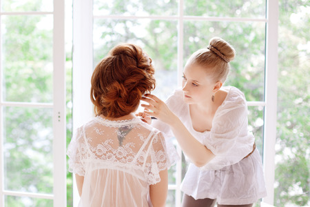 Stylist makes makeup bride on the wedding dayの写真素材