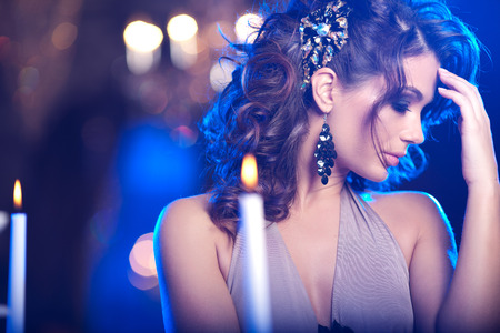 Luxury young woman in expensive interior. Girl with flawless makeup and evening volume hairstyle.の写真素材