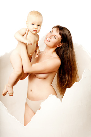 Kid with his young mother in the egg. Mom with baby in her arms. Family hug. Baby and his mum.の写真素材