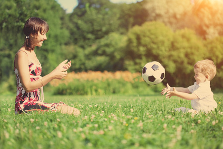 mother and son playing ball in the park.の写真素材