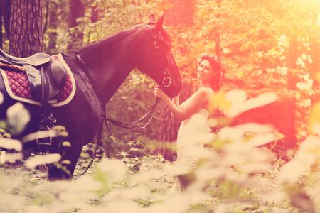 Beautiful woman and a dark horseの写真素材