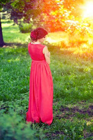 Beautiful woman with a flower in the hairstyle outdoorsの写真素材