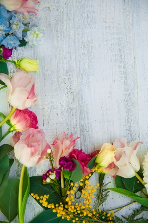 Spring flowers on wood background. Summer blooming border on a wooden table.の写真素材