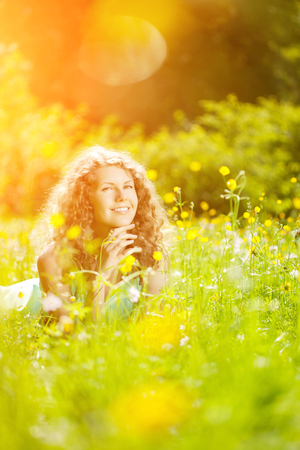 Young spring or summer fashion woman  in blowing garden spring landscape background. Springtime or summertime. Trendy girl at sunset. Allergic to pollen of flowers. Spring allergyの写真素材
