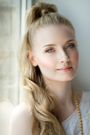 Romantic blonde. Young beautiful cute woman. Beauty girl with long shiny hair, glowing skin and voluminous haircutの写真素材