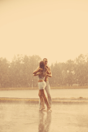 Loving couple in the rain barefoot. A man and a woman in love.の写真素材