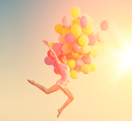 Girls with balloons at sunset. Stylish young women models against the sky celebrate a happy birthday.の写真素材