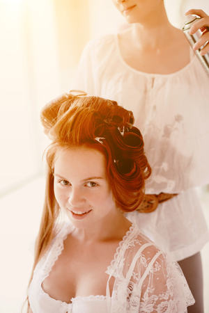 Hair stylist makes the bride on the wedding dayの写真素材