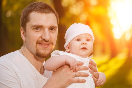 Baby with faher in the park in the rays of sunset. Toddler on the nature outdoors. Backlight....