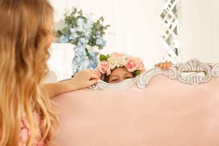 Girl playing hide and seek with her motherの写真素材