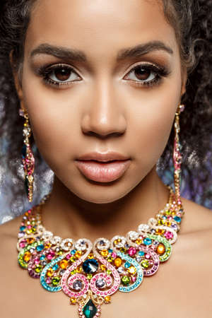 Beautiful model girl with set of Jewelry. Luxury girl in shine jewellry: Eearrings, Necklace, and Ring. Woman in jewelry from Gold, Precious Stones, Siamonds. Beauty and accessoriesの写真素材