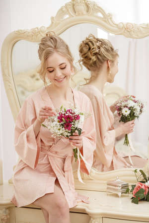 Bride with wedding flowers bouquet. Woman in wedding dress. Young fashion model with perfect skin, make up and Beautiful Hairstyle. Happy day. Marriage.の写真素材