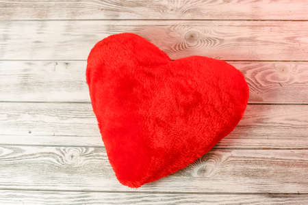 Red heart pillow on a wooden background. Valentines day, love concept.の写真素材