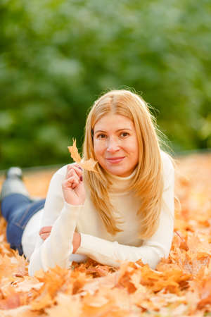 woman in the autumn park. Girl on a background of fall. Autumn yellow and red leavesの写真素材