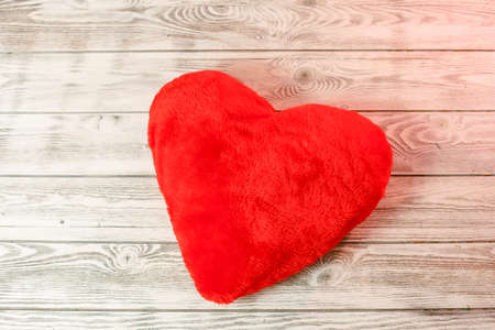 Red heart pillow on a wooden background. Valentines day concept.の写真素材