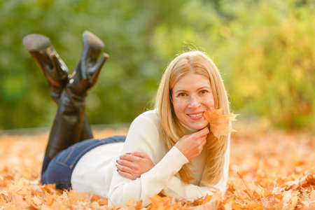 woman in the autumn park. Girl on a background of fall. Autumn yellow and red leavesの写真素材