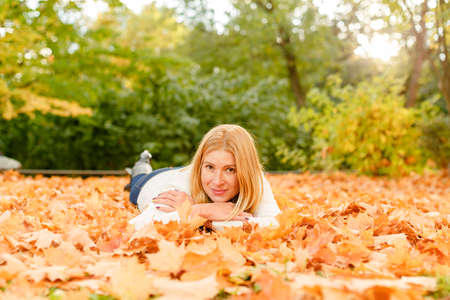 woman in the autumn park. Girl on a background of fall. Autumn yellow and red leavesの写真素材
