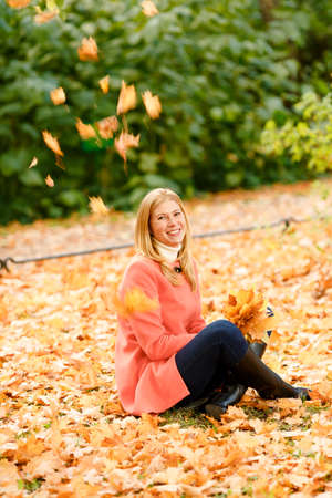 woman in the autumn park. Girl on a background of fall. Autumn yellow and red leavesの写真素材