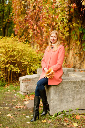 woman in the autumn park. Girl on a background of fall. Autumn yellow and red leavesの写真素材