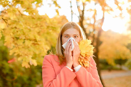A girl with a raft sneeze in the fall. Runny nose and other cold symptoms. Allergy.の写真素材
