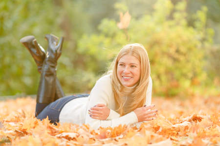 woman in the autumn park. Girl on a background of fall. Autumn yellow and red leavesの写真素材