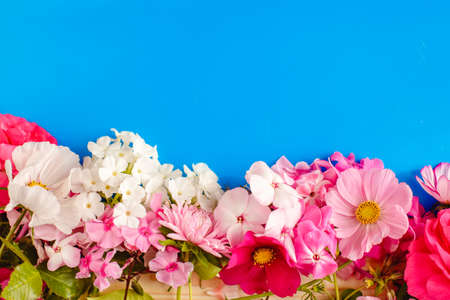 Floral summer background. Frame from spring flowers on a wooden background. Mother's day, easter or birthday cardの写真素材