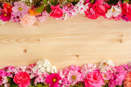 Floral summer background. Frame from spring flowers on a wooden background. Mother's day, easter or birthday cardの写真素材