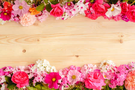 Floral summer background. Frame from spring flowers on a wooden background. Mother's day, easter or birthday cardの写真素材