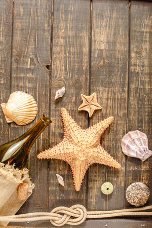 Sea and ocean gifts on a wooden background. marine things. sea products. Water Background for real captains and sailors. pirate design. Bottle, rope, star. underwater treasures.の写真素材