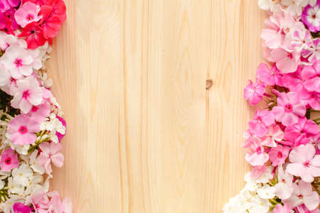 Floral summer background. Frame from spring flowers on a wooden background. Mother's day, easter or birthday cardの写真素材
