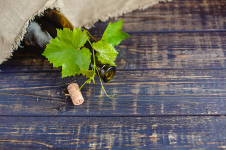 Wine bottle on a wooden background. Winemaking, sommelier.の写真素材